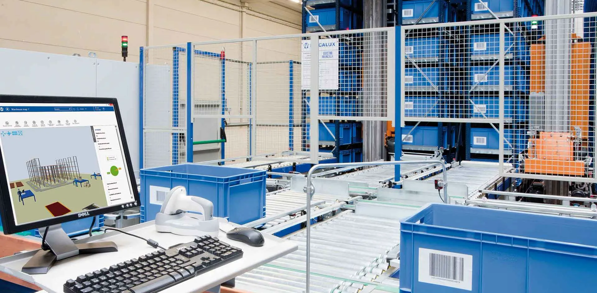 A worker at a control screen on a warehouse floor lined with high racking
